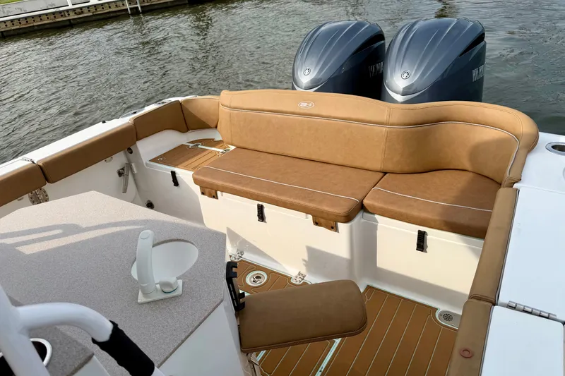 Slide: The Image of 2024 Sea Hunt Ultra 275SE boat interior with tan seating and dual engines. - 10