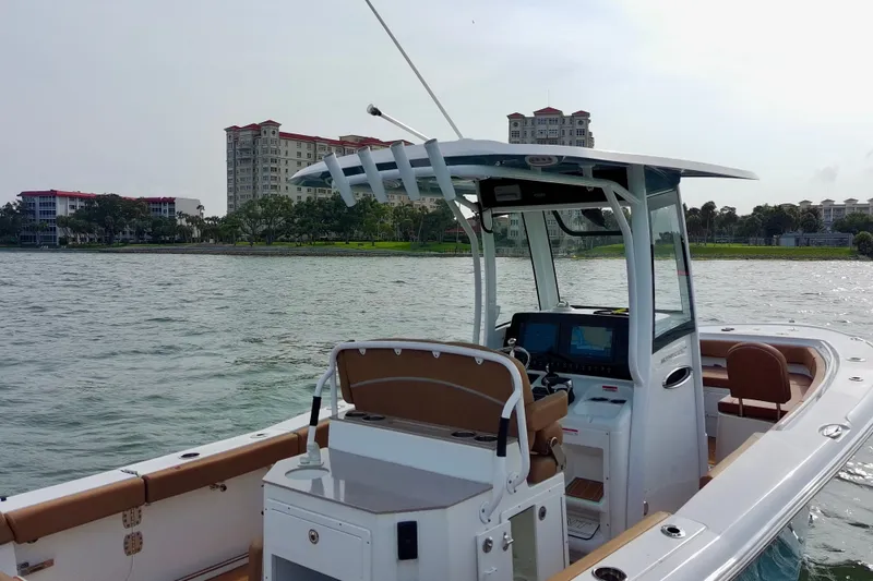 Slide: The Image of 2024 Sea Hunt Ultra 275SE boat on water, with modern console and scenic waterfront backdrop. - 12