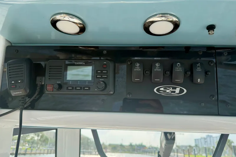Slide: The Image of 2024 Sea Hunt Ultra 275SE dashboard with Garmin radio and control switches. - 15