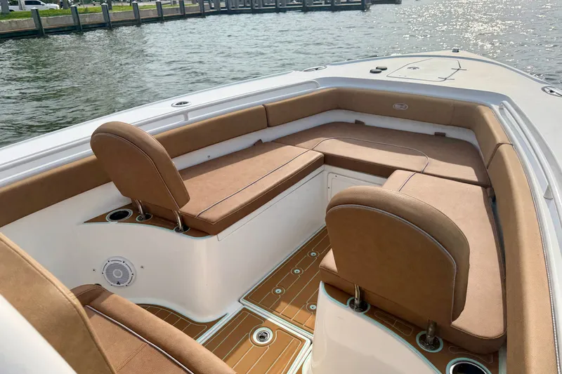 Slide: The Image of 2024 Sea Hunt Ultra 275SE boat interior with tan seating and wood-style flooring. - 19