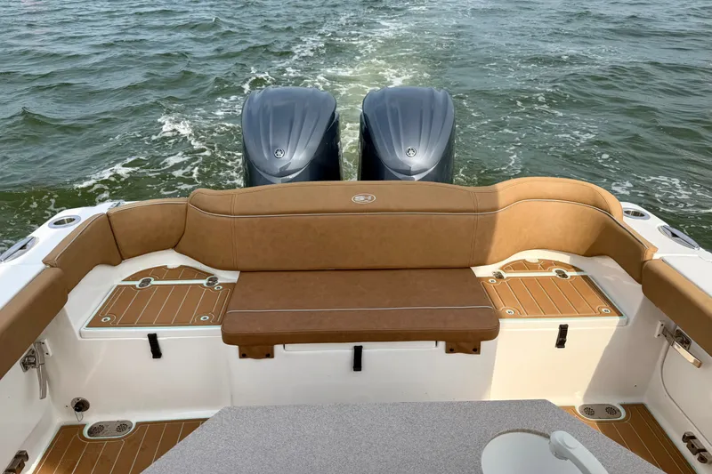 Slide: The Image of 2024 Sea Hunt Ultra 275SE boat with dual engines and tan seating on open water. - 8