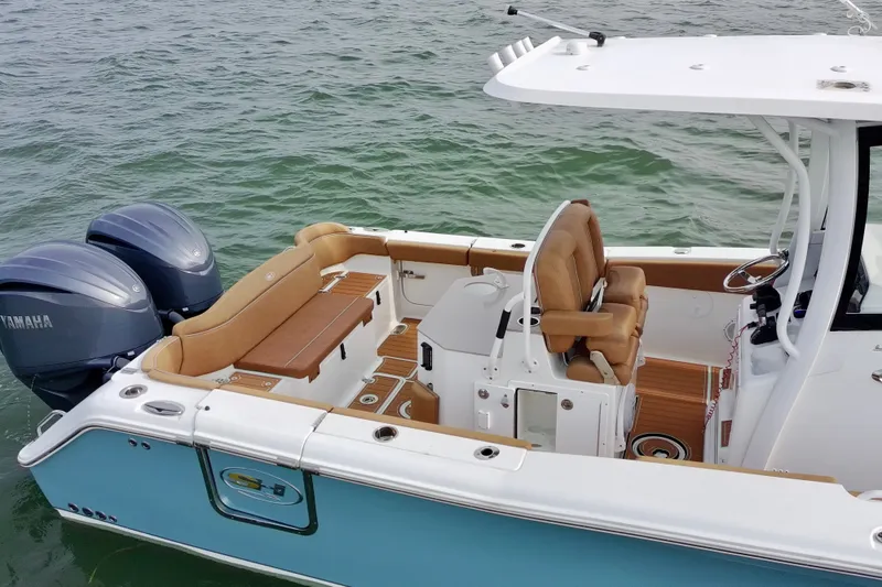 Slide: The Image of 2024 Sea Hunt Ultra 275SE boat with dual Yamaha engines on calm water. - 7