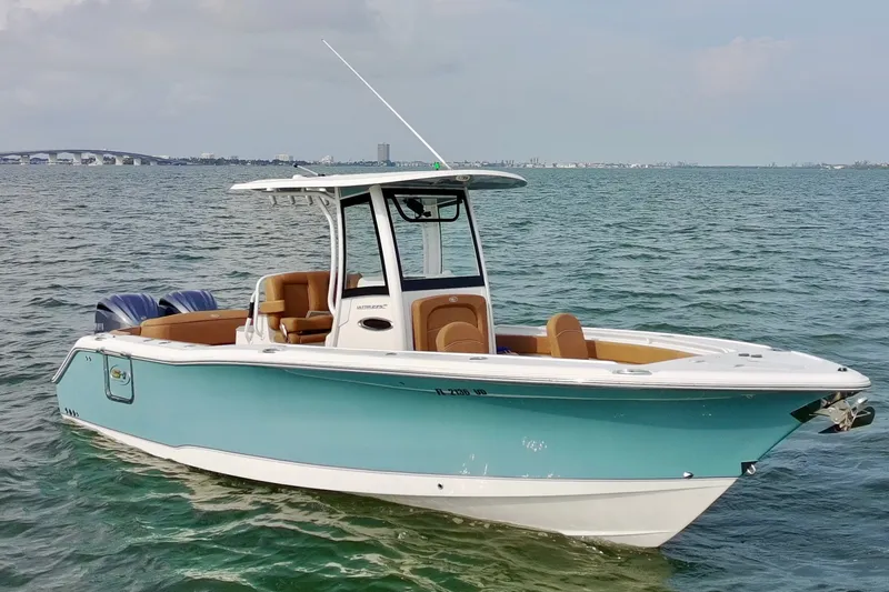 Slide: The Image of 2024 Sea Hunt Ultra 275SE boat on calm water, featuring sleek design and modern amenities. - 2