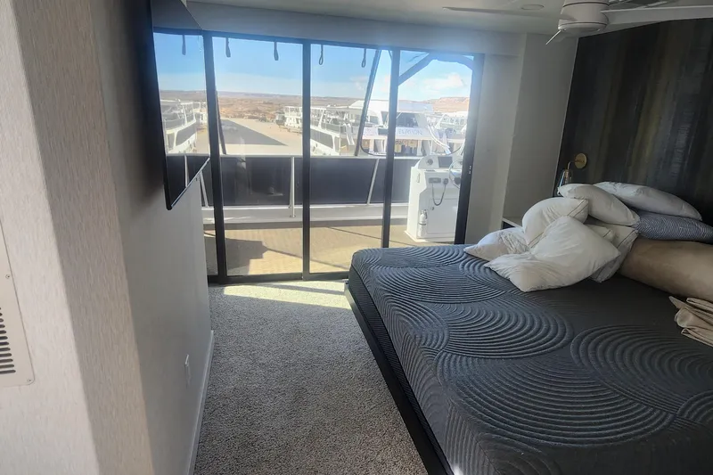 Slide: The Image of Modern bedroom on Adonia Legacy Trip #15 houseboat, featuring a large bed and scenic window view. - 21