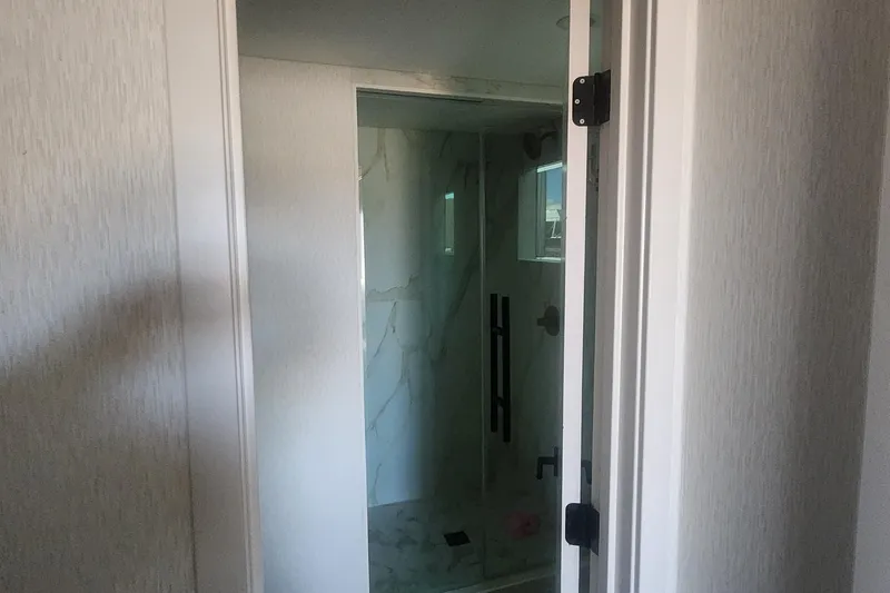 Slide: The Image of Modern bathroom with glass shower door, marble tiles, and sleek fixtures. Adonia Legacy Trip 2022. - 12