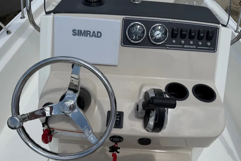 Slide: The Image of 2019 Boston Whaler 210 Montauk boat console with steering wheel and Simrad display. - 9