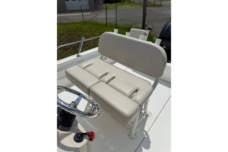 Slide: The Image of 2019 Boston Whaler 210 Montauk boat interior with cushioned seating and steering wheel. - 13
