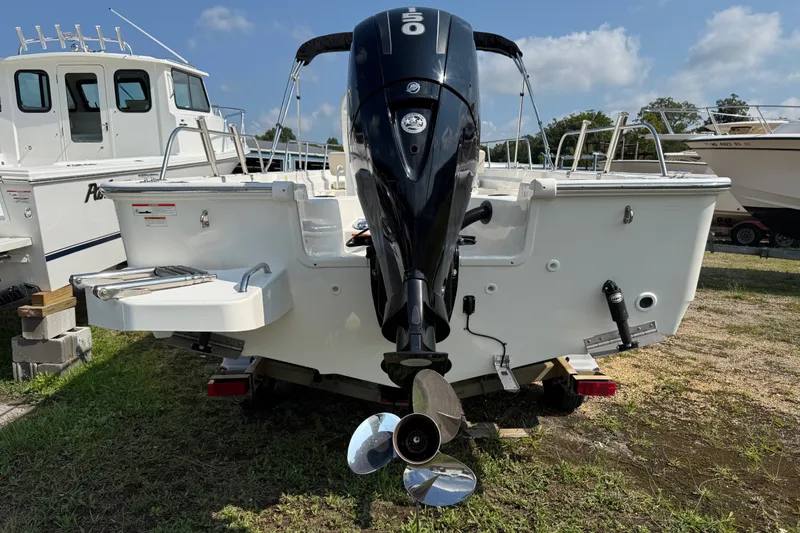 Slide: The Image of 2019 Boston Whaler 210 Montauk boat with outboard motor, parked on grass. - 3