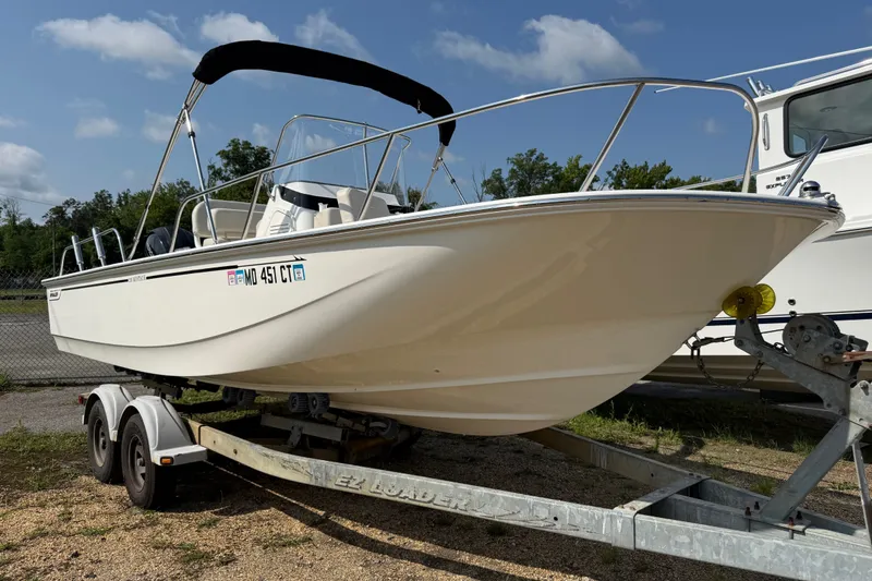 The Image of 2019 Boston Whaler 210 Montauk boat on trailer, parked outdoors under a clear sky. - 0