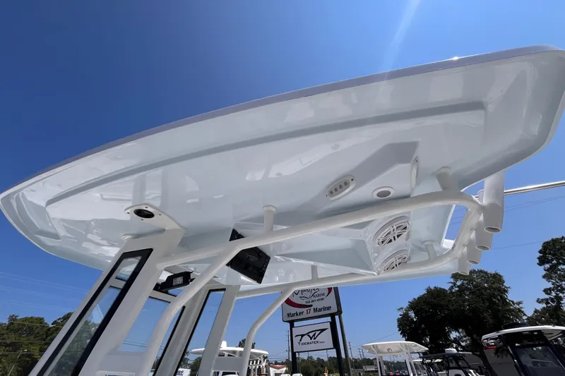 Slide: The Image of Tidewater 232 LXF 2027 boat's T-top under bright blue sky at a marine dealership. - 10