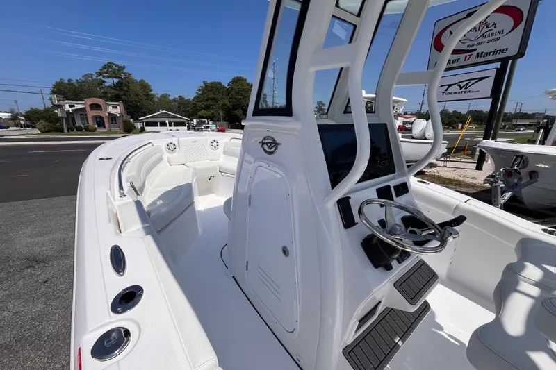 Slide: The Image of 2027 Tidewater 232 LXF boat interior with steering console and seating, displayed outdoors. - 9
