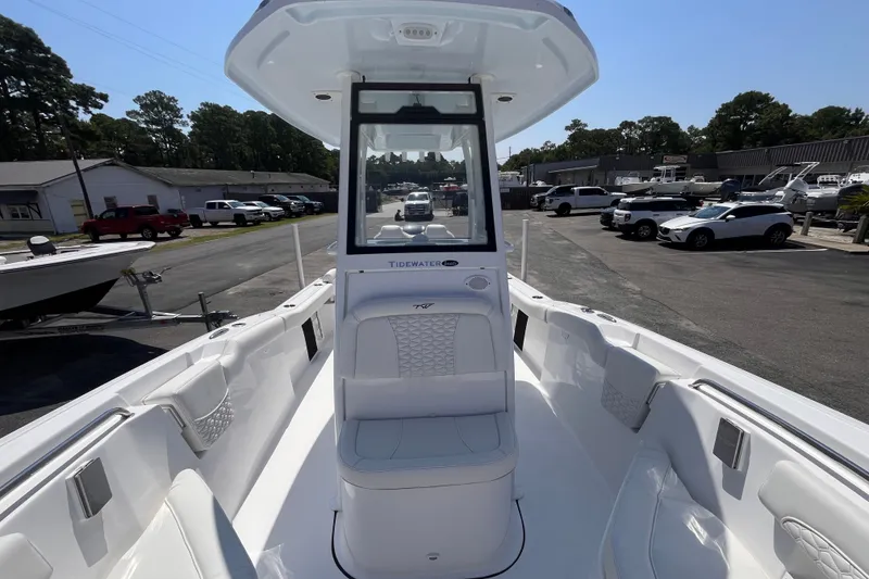 Slide: The Image of 2027 Tidewater 232 LXF boat interior, showcasing sleek seating and modern design in a marina setting. - 12