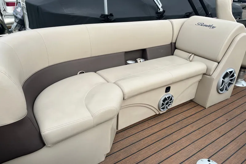 Slide: The Image of Luxurious seating on 2024 Bentley Pontoons Legacy 240 Navigator with integrated speakers and cup holders. - 6