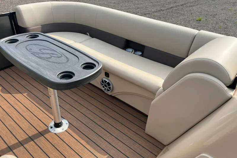 Slide: The Image of 2024 Bentley Pontoons Legacy 240 Navigator interior with beige seating and a central table. - 10