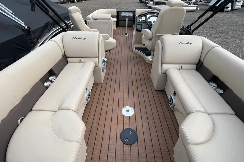 Slide: The Image of 2024 Bentley Pontoons Legacy 240 Navigator interior with luxurious seating and wood-style flooring. - 4