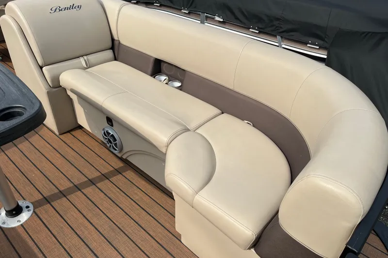 Slide: The Image of 2024 Bentley Pontoons Legacy 240 Navigator interior with beige seating and cup holders. - 11