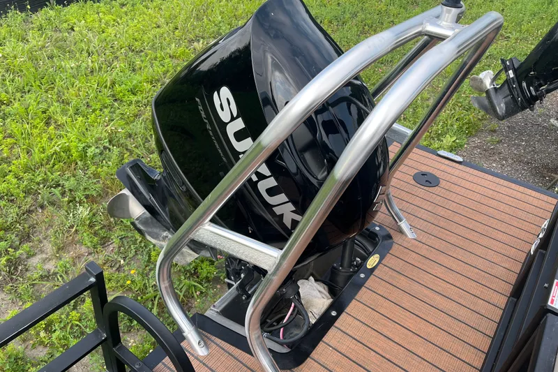 Slide: The Image of 2024 Bentley Pontoons Legacy 240 Navigator with Suzuki outboard motor on wooden deck. - 3