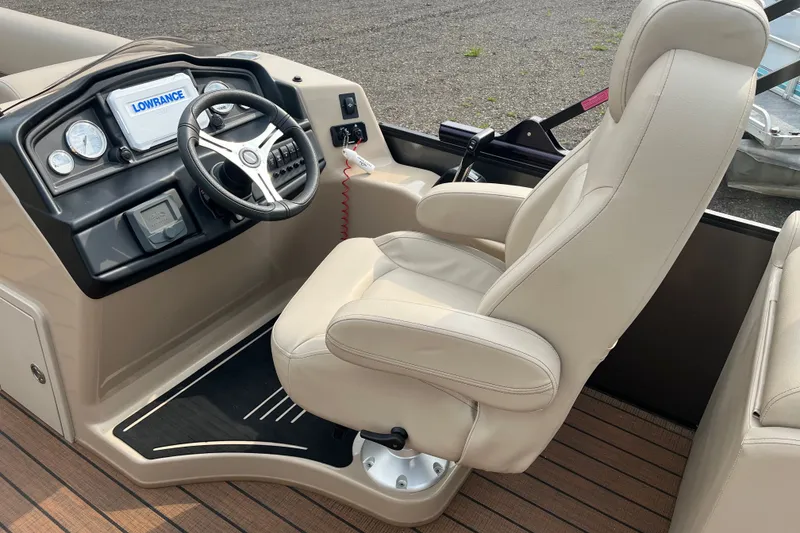Slide: The Image of 2024 Bentley Pontoons Legacy 240 Navigator helm with beige captain's chair and modern controls. - 7