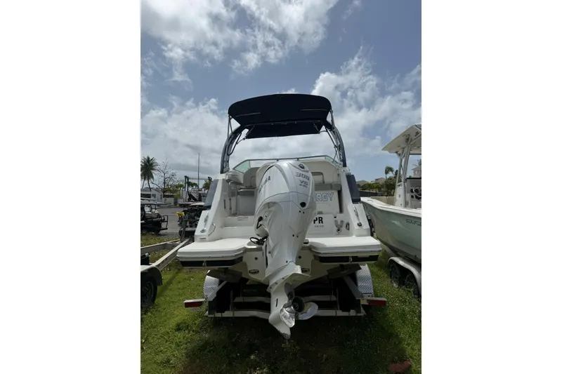 Slide: The Image of 2022 Regal 26 XO boat with Yamaha outboard motor, parked on grass under cloudy sky. - 7