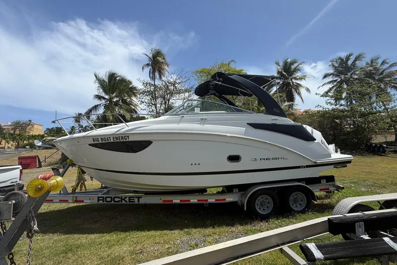 Slide: The Image of 2022 Regal 26 XO boat on trailer, surrounded by palm trees under a clear blue sky. - 2