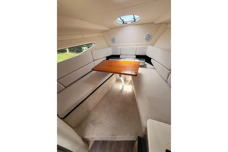 Slide: The Image of 2022 Regal 26 XO cabin interior with beige seating and wooden table. - 18
