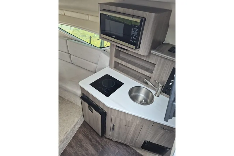 Slide: The Image of Compact kitchen area in 2022 Regal 26 XO boat with microwave, sink, and cooktop. - 17