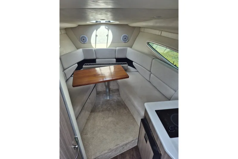 Slide: The Image of Interior of 2022 Regal 26 XO boat with cozy seating and wooden table. - 16