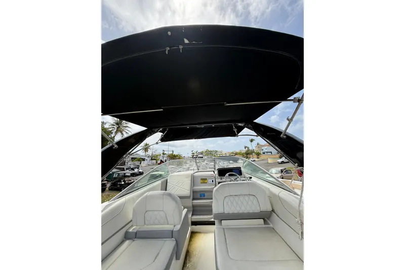 Slide: The Image of 2022 Regal 26 XO boat interior with seating and canopy under a blue sky. - 11
