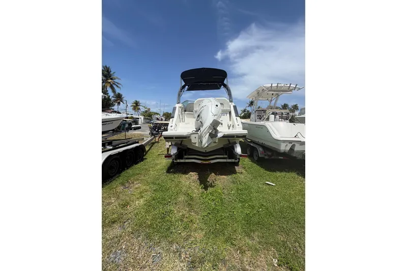 Slide: The Image of 2022 Regal 26 XO boat on trailer, parked on grass under clear blue sky. - 4