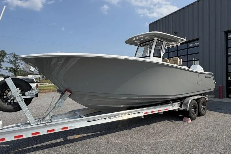 The Image of 2027 Sportsman Open 262 Center Console boat on trailer, parked outside a building. - 0