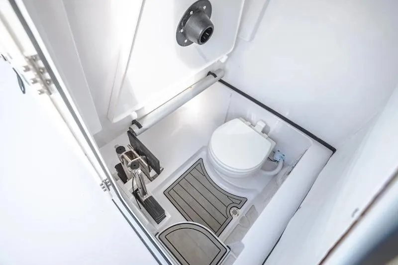 Slide: The Image of 2027 Sportsman Open 262 Center Console boat interior with compact marine toilet. - 14