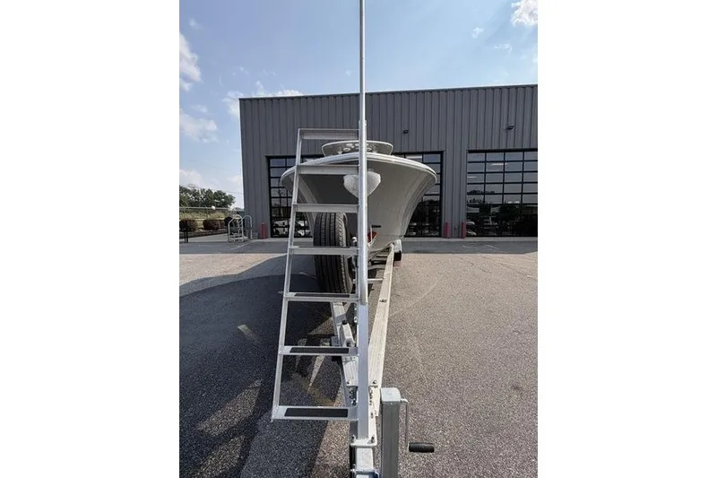 Slide: The Image of 2027 Sportsman Open 262 Center Console boat on trailer outside a warehouse. - 22
