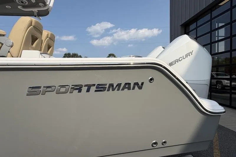 Slide: The Image of 2027 Sportsman Open 262 Center Console boat with Mercury engine, docked near a building. - 23