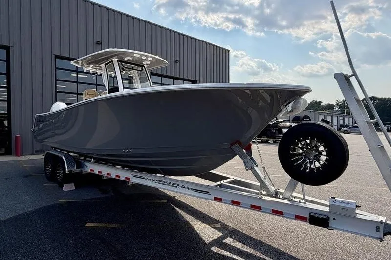 Slide: The Image of 2027 Sportsman Open 262 Center Console boat on trailer outside a warehouse. - 5