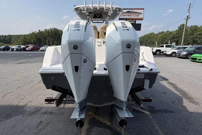 Slide: The Image of 2027 Sportsman Open 262 Center Console with dual outboard engines in a parking lot. - 2