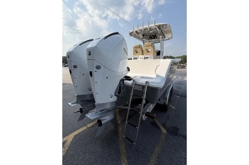 Slide: The Image of 2027 Sportsman Open 262 Center Console boat with dual engines and ladder, parked outdoors. - 19