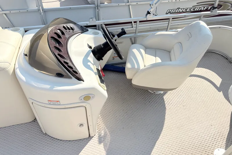 Slide: The Image of 2006 Bennington 2050GL boat interior with steering console and white captain's chair. - 13