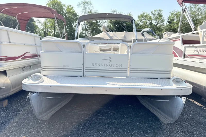 Slide: The Image of 2006 Bennington 2050GL pontoon boat, docked with surrounding boats, sunny day. - 2