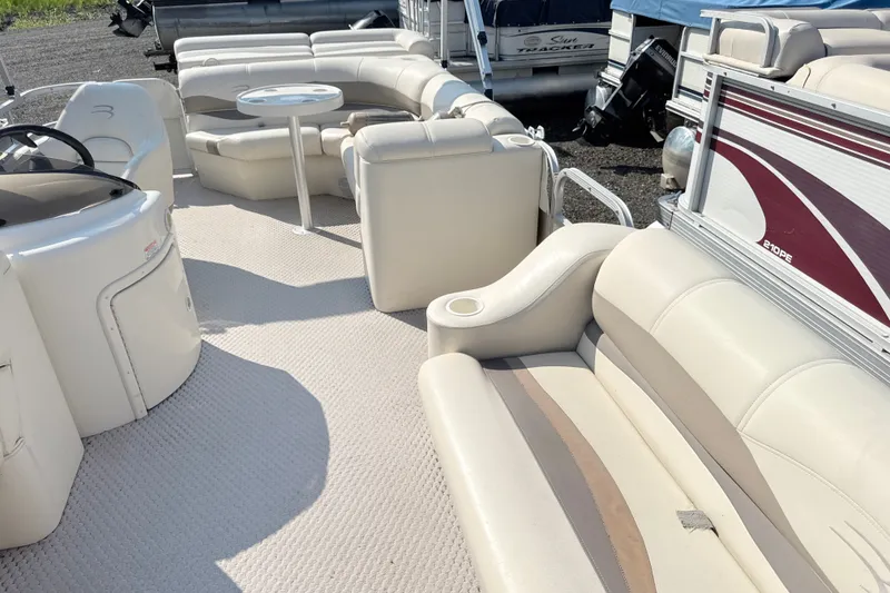Slide: The Image of 2006 Bennington 2050GL pontoon boat interior with beige seating and table. - 10