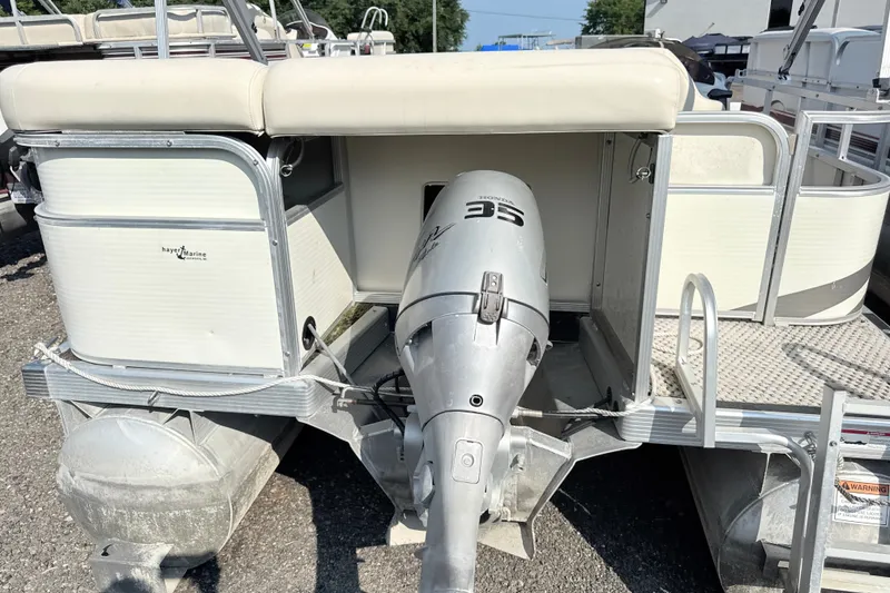 Slide: The Image of 2006 Bennington 2050GL pontoon boat with Honda outboard motor, docked on gravel. - 7
