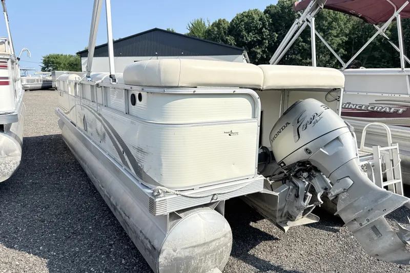 Slide: The Image of 2006 Bennington 2050GL pontoon boat with Honda outboard motor, parked on gravel lot. - 5
