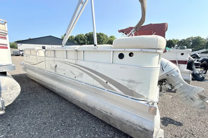 Slide: The Image of 2006 Bennington 2050GL pontoon boat with outboard motor, parked on gravel lot. - 4