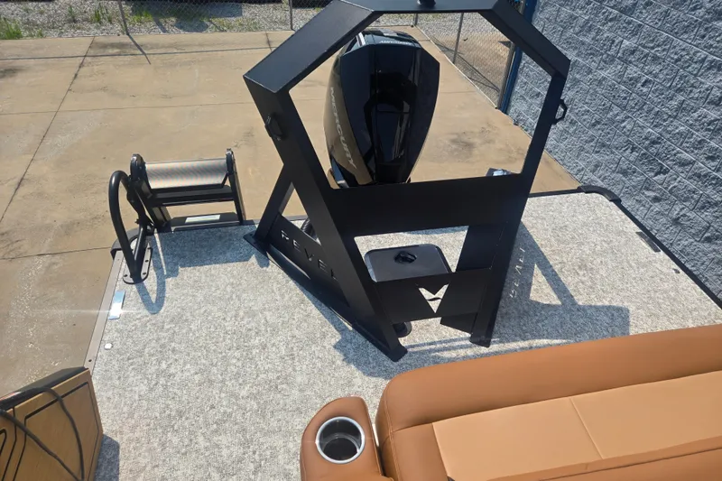 Slide: The Image of The image shows the rear of a Revel RL23 boat with an outboard motor and seating area. - 11