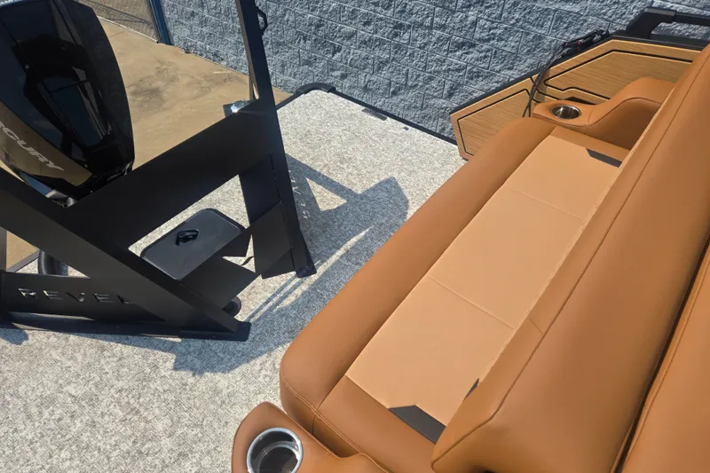 Slide: The Image of The image shows the deck of a Revel RL23 boat with brown seating and an engine. - 12