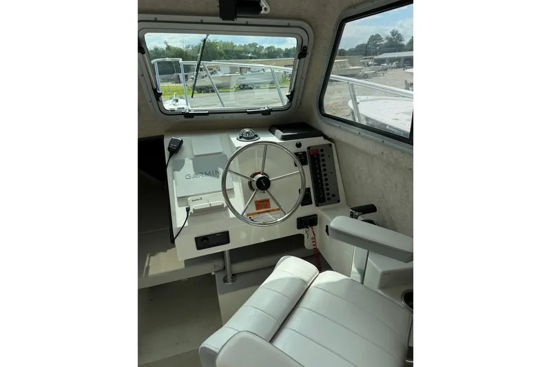 Slide: The Image of Interior of 2024 Parker 2320 Sport Cabin boat with steering wheel and Garmin navigation system. - 10