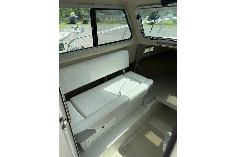 Slide: The Image of 2024 Parker 2320 Sport Cabin interior with white seating and large windows. - 11