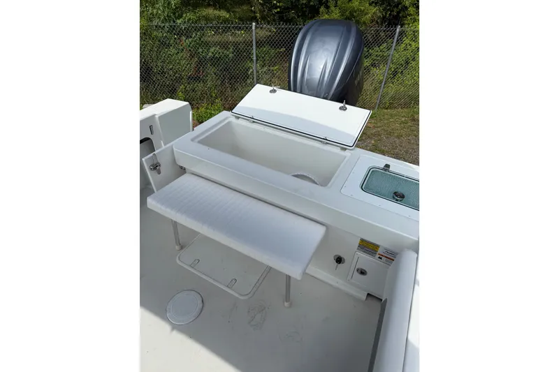 Slide: The Image of 2024 Parker 2320 Sport Cabin boat interior with open storage compartment and seating. - 19