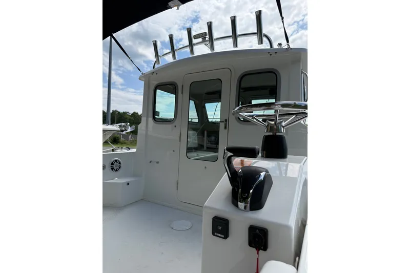 Slide: The Image of 2024 Parker 2320 Sport Cabin boat interior with steering wheel and control panel. - 6