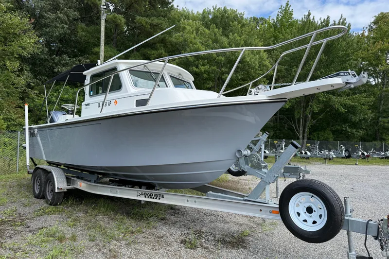 The Image of 2024 Parker 2320 Sport Cabin boat on trailer, parked outdoors. - 1