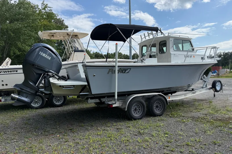 Slide: The Image of 2024 Parker 2320 Sport Cabin boat on trailer with Yamaha outboard motor. - 2